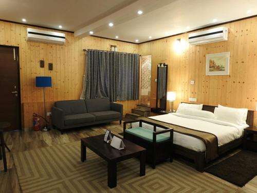 Kurseong的住宿－Nirvana Retreat，一间卧室配有一张大床、一张沙发和一张沙发。
