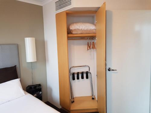 a room with a closet with a bed and a door at Parramatta Hotel Apartment in Sydney