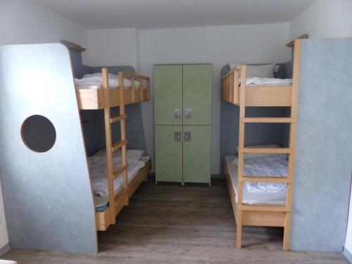 a room with three bunk beds and a ladder at Bernsteinreiter Erlebnishof Barth, Bernsteinsuite 11 in Barth