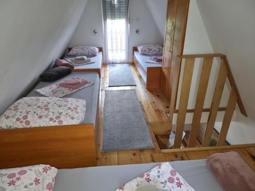 a room with three bunk beds and a staircase at Kuća za odmor Apathy in Opatovac