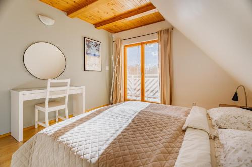1 dormitorio con cama, escritorio y espejo en Dom pod Klonem, en Jantar