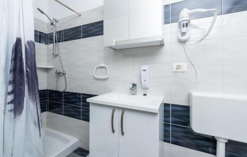 een witte badkamer met een wastafel en een douche bij Holiday House Pudarica in Rovinjsko Selo