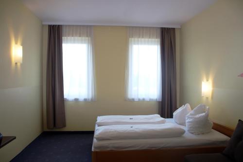 a hotel room with a bed and two windows at NOVAPARK Flugzeughotel Graz in Graz