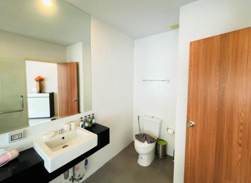 a bathroom with a sink and a toilet and a mirror at Chic Condo in Karon by Lofty in Karon Beach