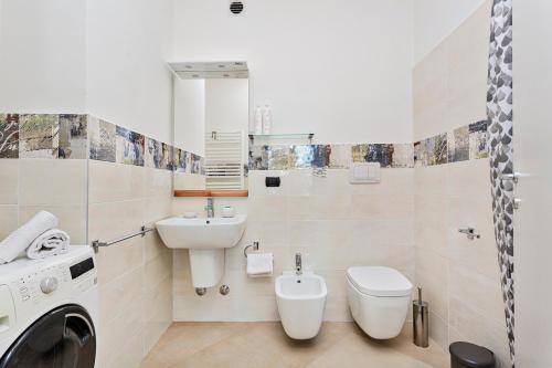 bagno con lavandino, servizi igienici e lavatrice di Le Chicche del Porto - Bleu a Genova