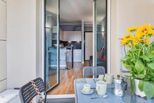 a dining room with a table and a kitchen at Le Chicche del Porto - Bleu in Genova