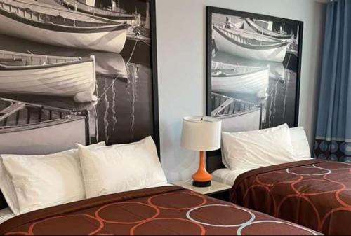 a bedroom with two beds and a picture of boats at Super 8 by Wyndham Lindenhurst in Lindenhurst
