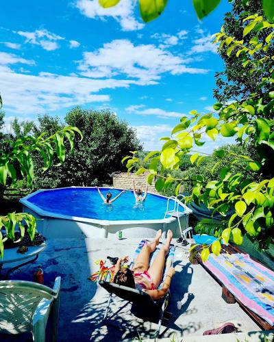 two people laying in hammocks next to a swimming pool at Kuća za odmor Apathy in Opatovac