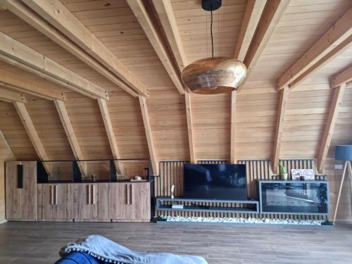 Zimmer mit Holzdecke, Sofa und TV in der Unterkunft Batllava Premium Resort Villa 2 in Orllan