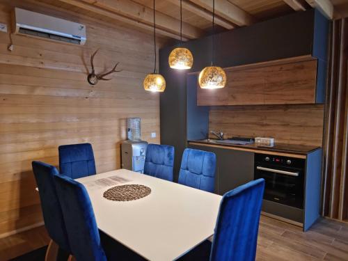 eine Küche mit einem weißen Tisch und blauen Stühlen in der Unterkunft Batllava Premium Resort Villa 2 in Orllan