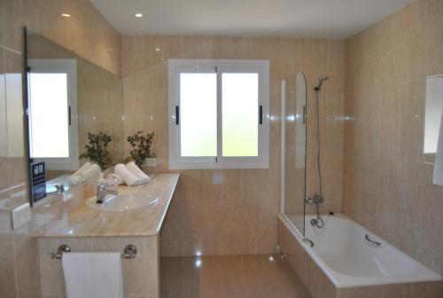 a bathroom with a tub and a sink and a bath tub at Villa Teresa in Colònia de Sant Jordi