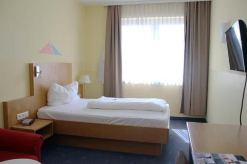 a hotel room with a bed and a window at NOVAPARK Flugzeughotel Graz in Graz