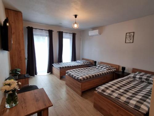 um quarto de hotel com duas camas e uma mesa em Pokoje pod Wietrznią em Kielce