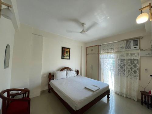 a bedroom with a bed with white sheets and a window at Homestay in Varanasi