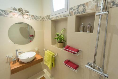 La salle de bains est pourvue d'un lavabo et d'un miroir. dans l'établissement Hasambarana Apparthotel, à Antananarivo