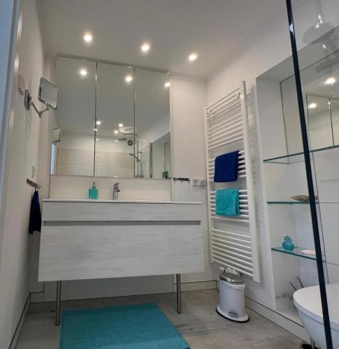 a white bathroom with a sink and a mirror at Wohnen an der Havel in Schwielowsee