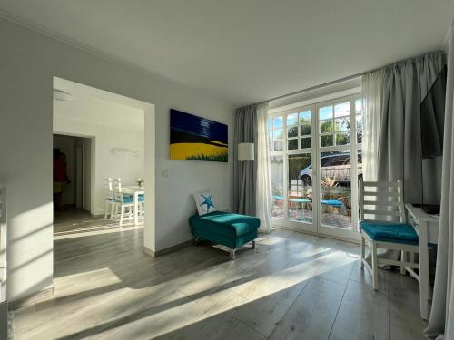 ein Wohnzimmer mit einem grünen Stuhl und einem Tisch in der Unterkunft Wohnen an der Havel in Schwielowsee