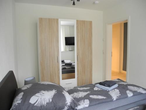 a bedroom with a bed and a mirror at Strandappartements Steinberghaff "Sonderborg" mit Parkblick in Steinberg