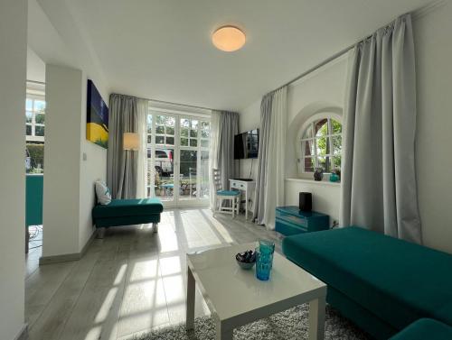 ein Wohnzimmer mit einem grünen Sofa und einem Tisch in der Unterkunft Wohnen an der Havel in Schwielowsee