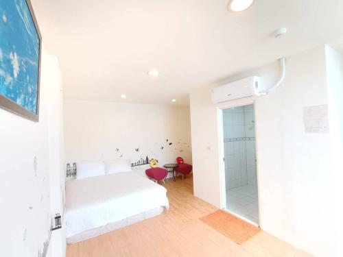 a white bedroom with a bed and a walk in shower at Julie's Garden in Hengchun South Gate