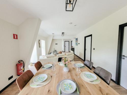 a dining room with a wooden table and chairs at Au bout de mes rêves in Walcourt