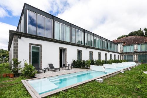 an external view of a house with a swimming pool at Octant Furnas in Furnas