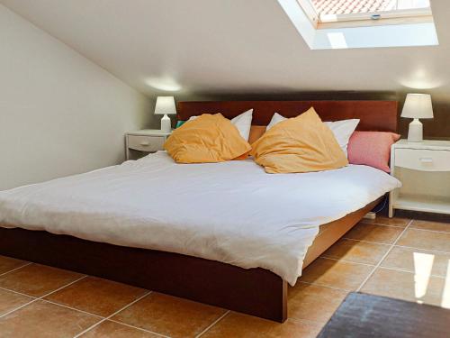a bedroom with a bed with orange pillows on it at Cloud to Chill Surfhouse Baleal in Ferrel