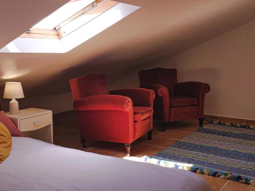 a bedroom with two chairs and a bed and a skylight at Cloud to Chill Surfhouse Baleal in Ferrel