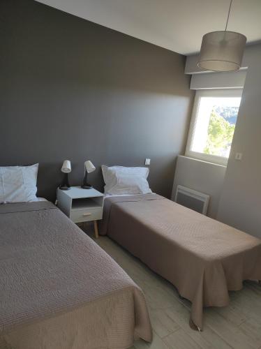 a bedroom with two beds and a window at Villa Romane in Aubenas