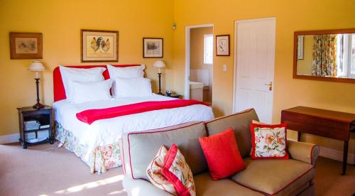 a bedroom with a large bed and a couch at Watersmeet cottages in Dullstroom