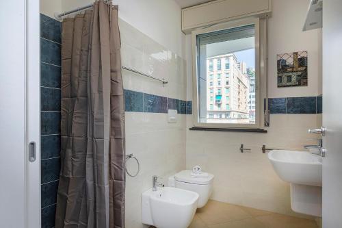 uma casa de banho com um lavatório, um WC e uma janela. em Le Chicche del Porto - Allure em Gênova