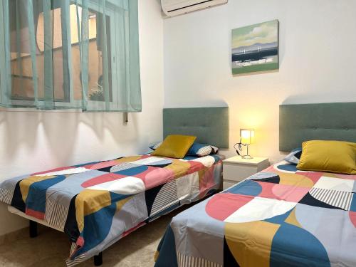 Duas camas num quarto com uma janela em Apartamento Ninfa - Wifi, Piscina, A/C, Lavadora, silla de ruedas bienvenidas em Fuengirola