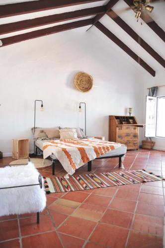 a bedroom with a bed and a table in a room at Casa Nidra in Jimena de la Frontera