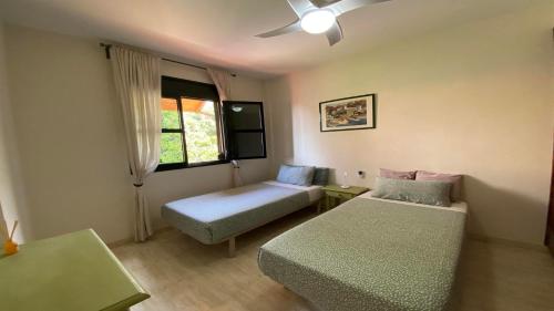 um quarto com uma cama, um sofá e uma janela em La Tajea del Turno em Valle Gran Rey
