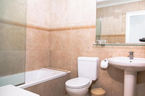 a bathroom with a toilet and a sink and a bath tub at Westhaven Bay in Costa Del Silencio