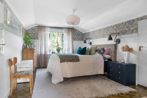 1 dormitorio con 1 cama grande y 1 silla en Charming cottage outside Rattvik, en Vikarbyn