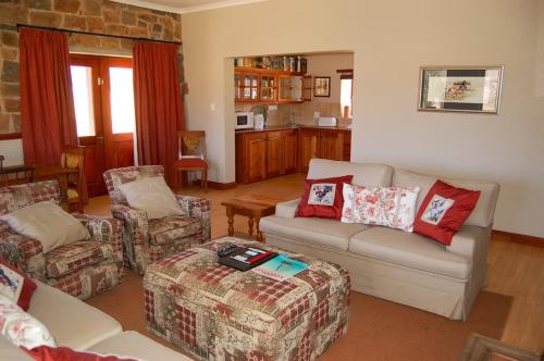 a living room with a couch and two chairs at Watersmeet cottages in Dullstroom