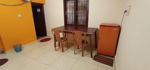 a wooden table and two chairs in a room at Coorg girinivas homestay 102 in Madikeri