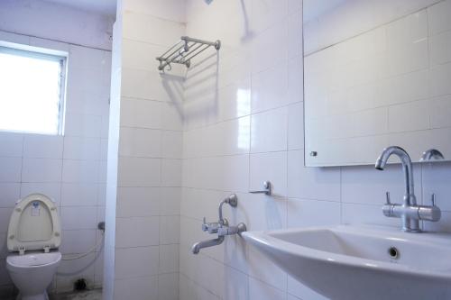 Baño blanco con lavabo y aseo en Hotel Chandra, en Jamshedpur