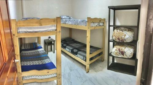 2 Etagenbetten in einem Zimmer mit einem Zimmer mit einem anderen Bett in der Unterkunft Colibrí Hostel in Puerto Iguazú