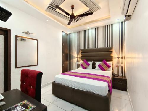 a bedroom with a bed and a table and a chair at Hotel Jai Surya in Patiāla