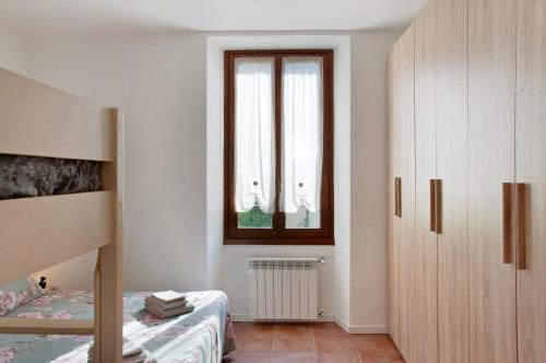 a bedroom with a bunk bed and a window at Casa Sole in Novate Mezzola