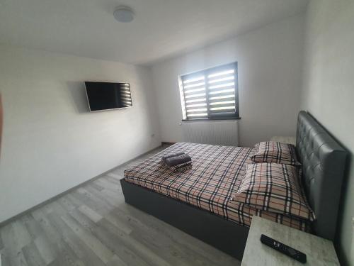 a small bedroom with a bed and a television at Apartament Nicole in Curtea de Argeş