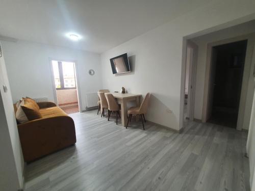 a living room with a couch and a table and chairs at Apartament Nicole in Curtea de Argeş