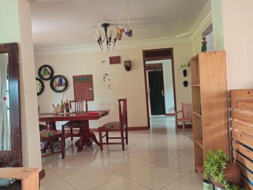 a living room with a table and a dining room at Aivilo Home in Kampala