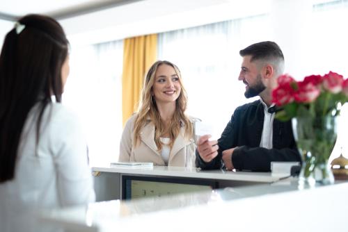 a man and woman sitting at a table in a meeting at Hotel Messa in Władysławowo