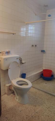 a bathroom with a toilet and a bath tub at Bluebell Apartments in Diani Beach