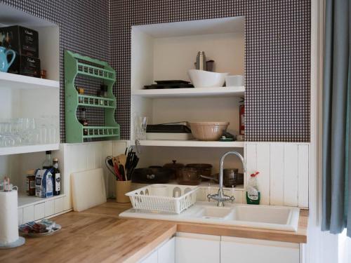 una cocina con 2 lavabos y estanterías con utensilios en Pass the Keys Artistic and Stylish 2 Bedroom Flat in City Centre, en Glasgow