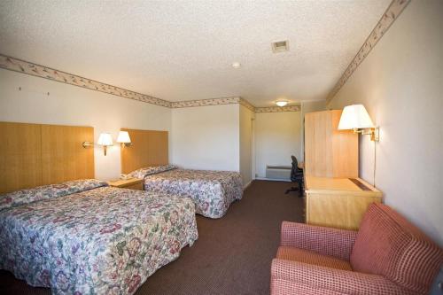 een hotelkamer met 2 bedden en een stoel bij Americas Best Value Inn Greenbush Albany in East Greenbush