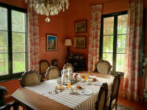 een eetkamer met een tafel, stoelen en ramen bij Centro Ecuestre Frasco Chico in Lobos